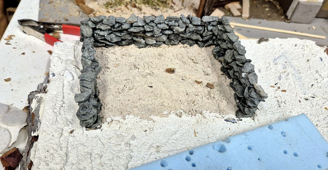 Die Grundplatte mit der ersten Trockensteinmauer