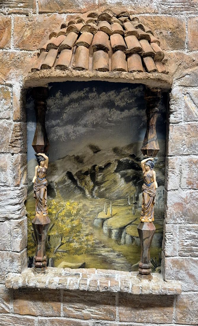 Die Nische mit gemalter Landschaft und zwei kleinen Säulenfiguren